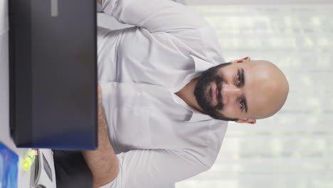 Vertical-video-of-Home-office-worker-man-winks-at-camera.